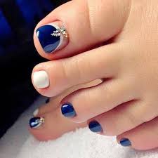 Descripción Los dedos de una mujer con uñas de los pies azules y blancos.
