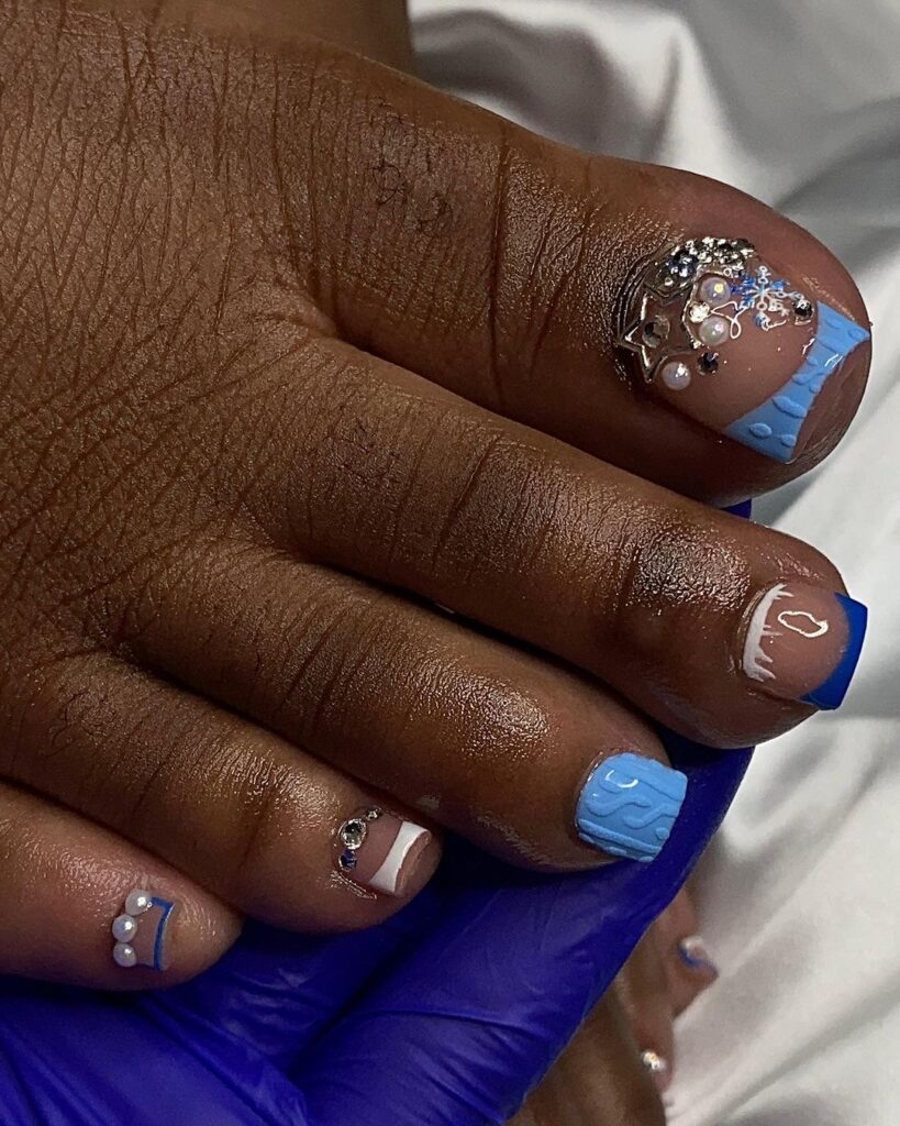 Las uñas de los pies de una mujer con diseños azules y blancos.