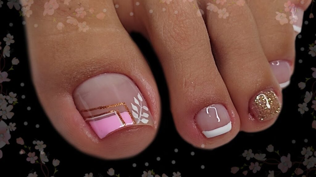 Las uñas de los pies de una mujer con diseños en rosa y dorado.